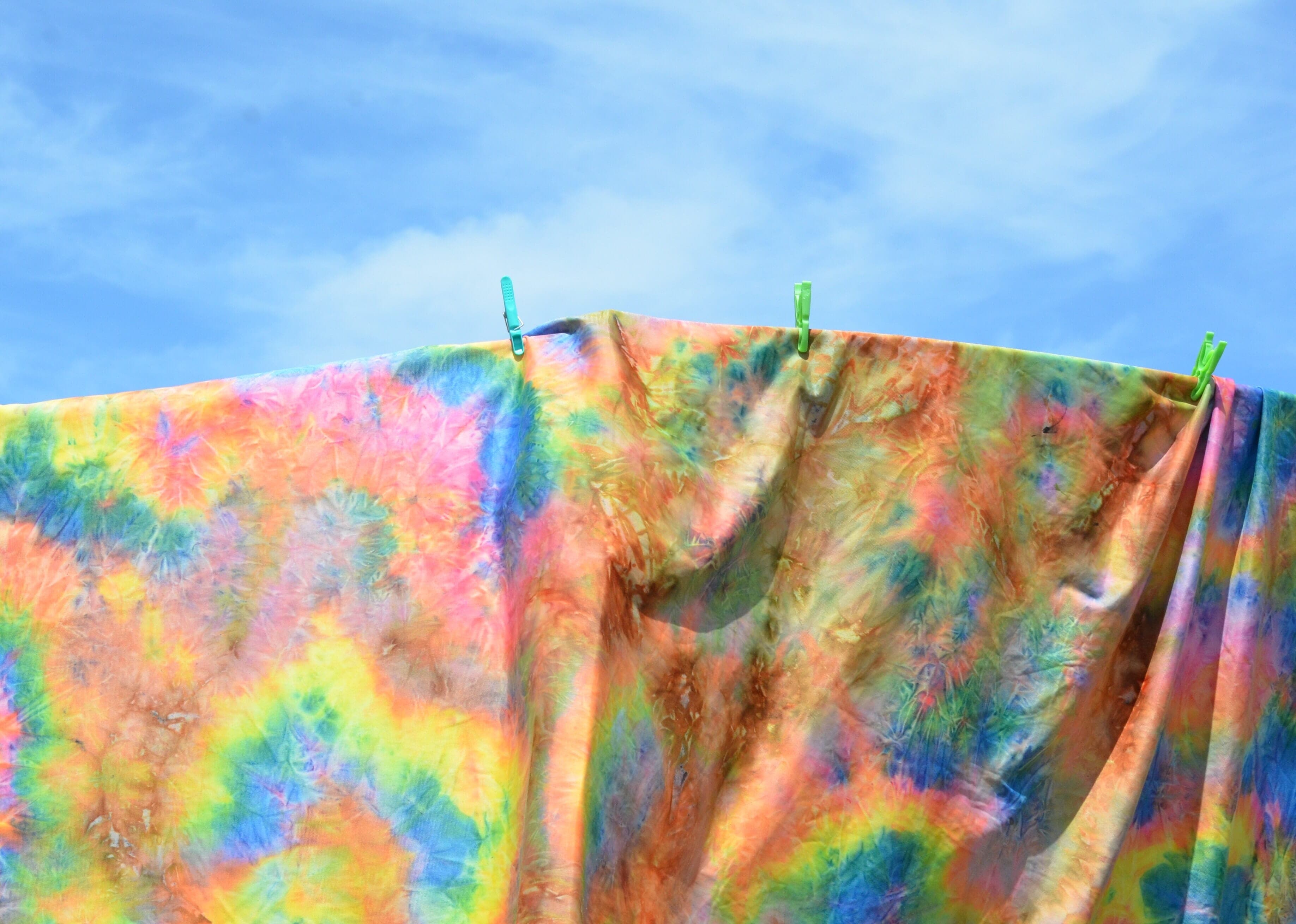 A tie dye sheet hanging from a clothes line